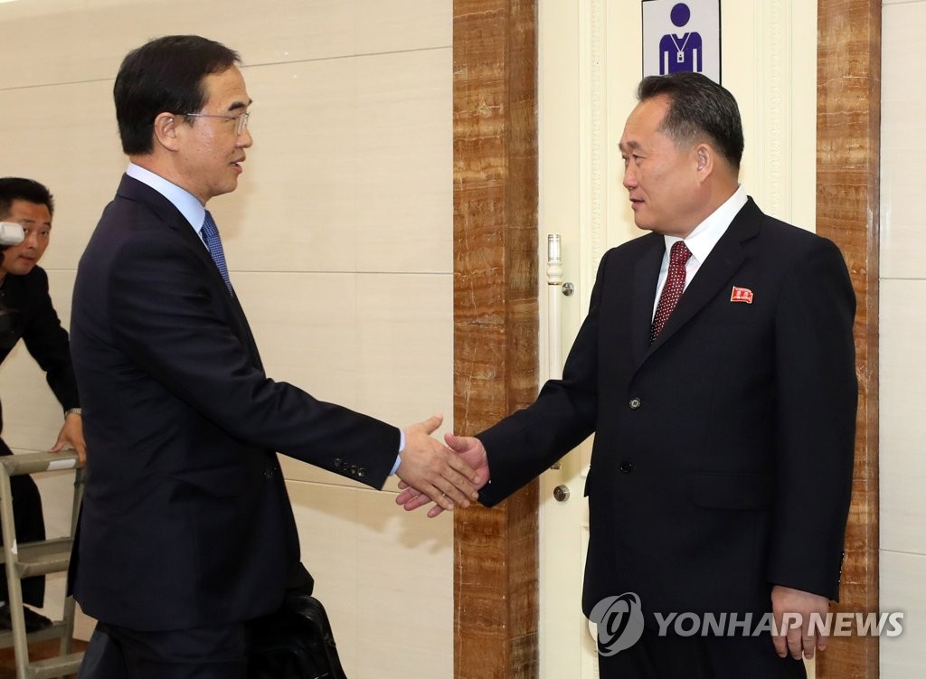 10月4日，韩国统一部长官赵明均（左）飞赴平壤国际机场后，同朝鲜祖国和平统一委员会委员长李善权握手。（韩联社/联合采访团）