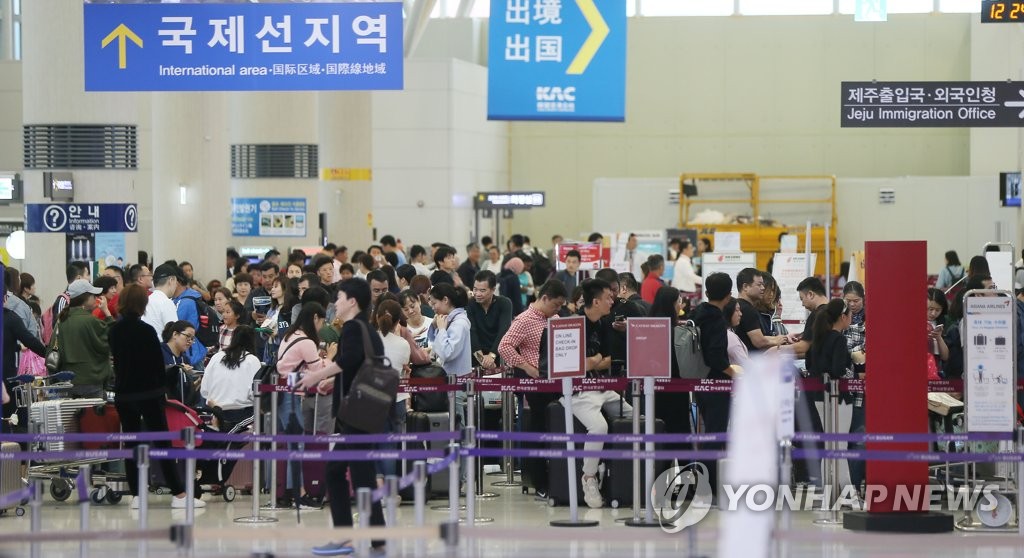 资料图片：2018年的济州国际机场外国游客如潮。 韩联社