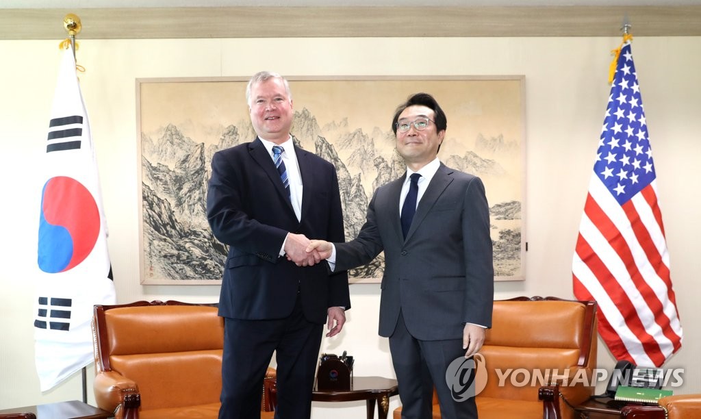 10月29日上午，在韩国外交部，李度勋（右）和比根握手合影。（韩联社）