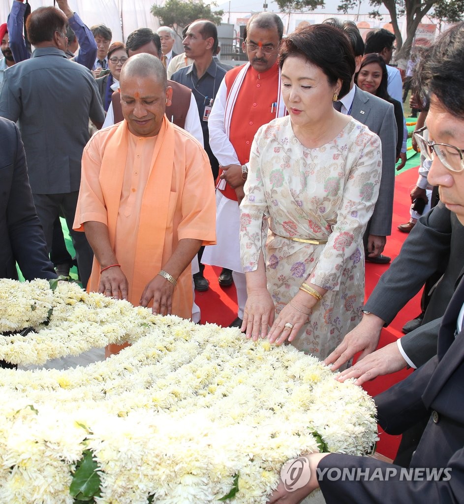 当地时间11月6日下午，在印度阿约提亚，韩国总统文在寅夫人金正淑（右）向许王后纪念碑献花。（韩联社）