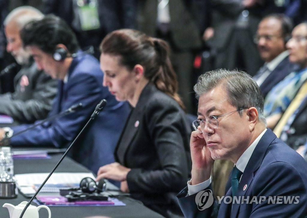 当地时间11月15日上午，在新加坡新达城国际会展中心，韩国总统文在寅（右）出席第13届东亚峰会并听取各国领导人发言。（韩联社）
