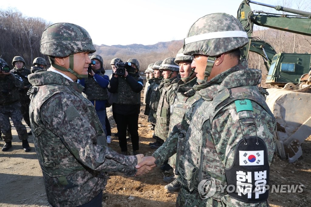 资料图片：2018年11月22日，在非军事区，韩国国防部次官（副部长，左）走访韩朝为共同挖掘韩国战争阵亡人员遗骸建设道路的施工现场，勉励官兵。（韩联社/联合采访团)