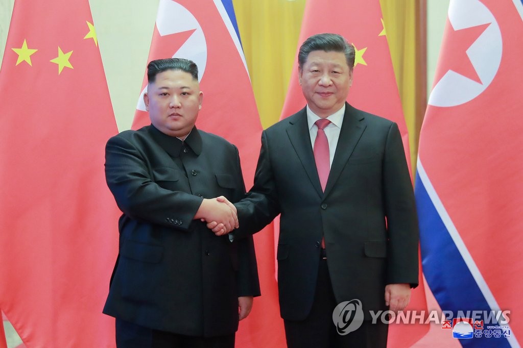 朝中社1月10日刊载朝鲜国务委员会委员长金正恩（左）同中国国家主席习近平握手图片。图片仅限韩国国内使用，严禁转载复制。（韩联社/朝中社）