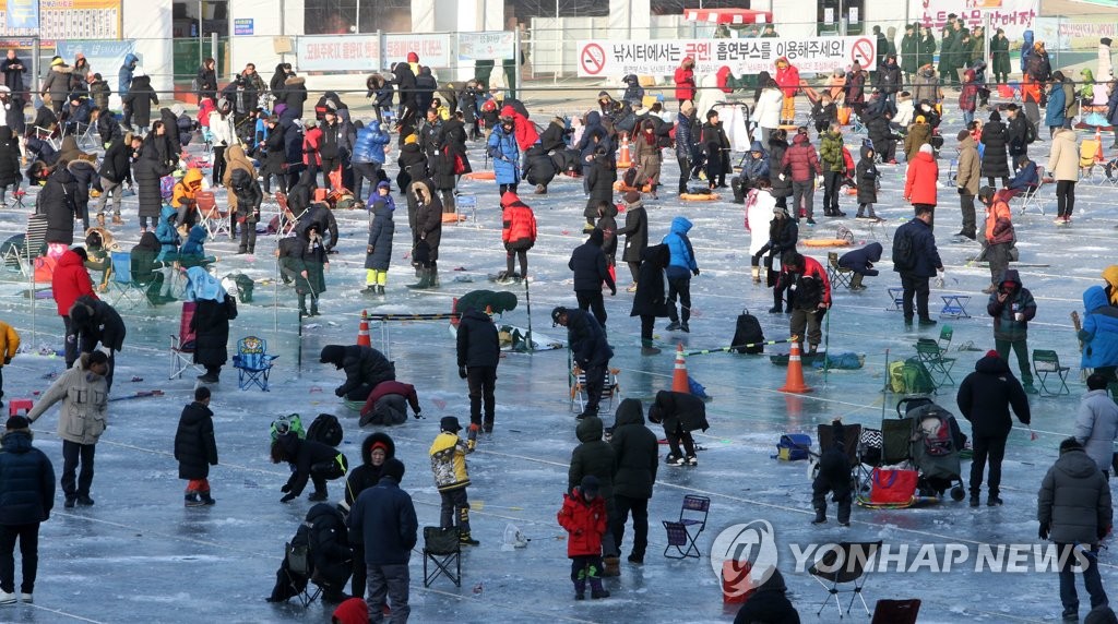 资料图片：1月20日，华川山鳟鱼冰钓场人头攒动。（韩联社）