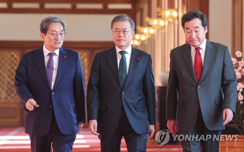 资料图片：1月22日，在青瓦台，文在寅（居中）与国务总理李洛渊（右）、卢英敏一起走入国务会议会场。（韩联社）