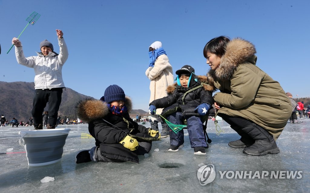 1月27日，在江原道麟蹄郡举行的第19届麟蹄钓冰鱼节上，一家人正在钓冰鱼，度过愉快的时光。（韩联社）