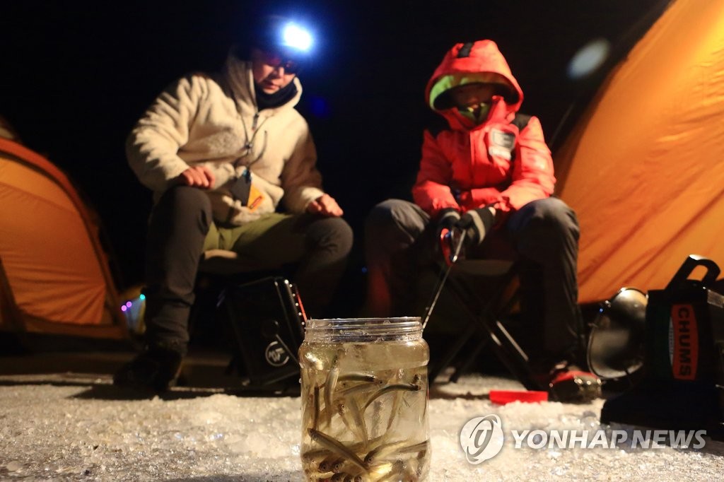 1月28日，在江原道麟蹄郡昭阳江上游冰面上，访客们享受夜间钓鱼的乐趣。（麟蹄郡政府供图)