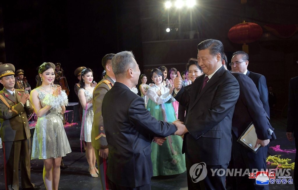 图为中国国家主席习近平（右）在观看演出后与朝方人士亲切握手并竖起大拇指称赞。图片仅限韩国国内使用，严禁转载复制。（韩联社/朝中社）