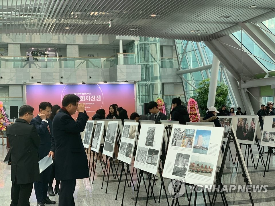1月31日，中国改革开放40年主题国际巡展在韩国国会议员会馆开幕。图为访客认真观展。（韩联社）