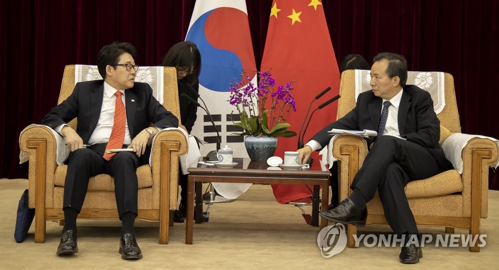 资料图片：2月26日，在北京，韩国环境部部长赵明来（左）同中国生态环境部部长李干杰举行会晤。（韩联社）