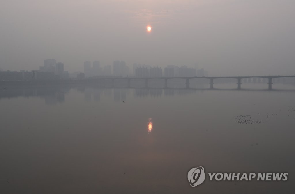 资料图片：3月6日，在首尔麻浦大桥上远眺，初升的太阳被雾霾笼罩。（韩联社）
