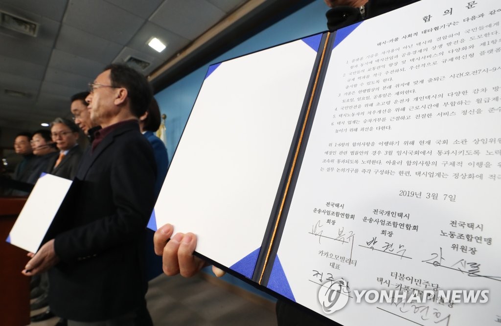 3月7日，在韩国国会，出租车行业四团体代表、拼车软件企业代表与共同民主党专项工作组（TF）委员长全贤姬（中）等有关人士在签署拼车软件相关协议后合影留念。（韩联社） 