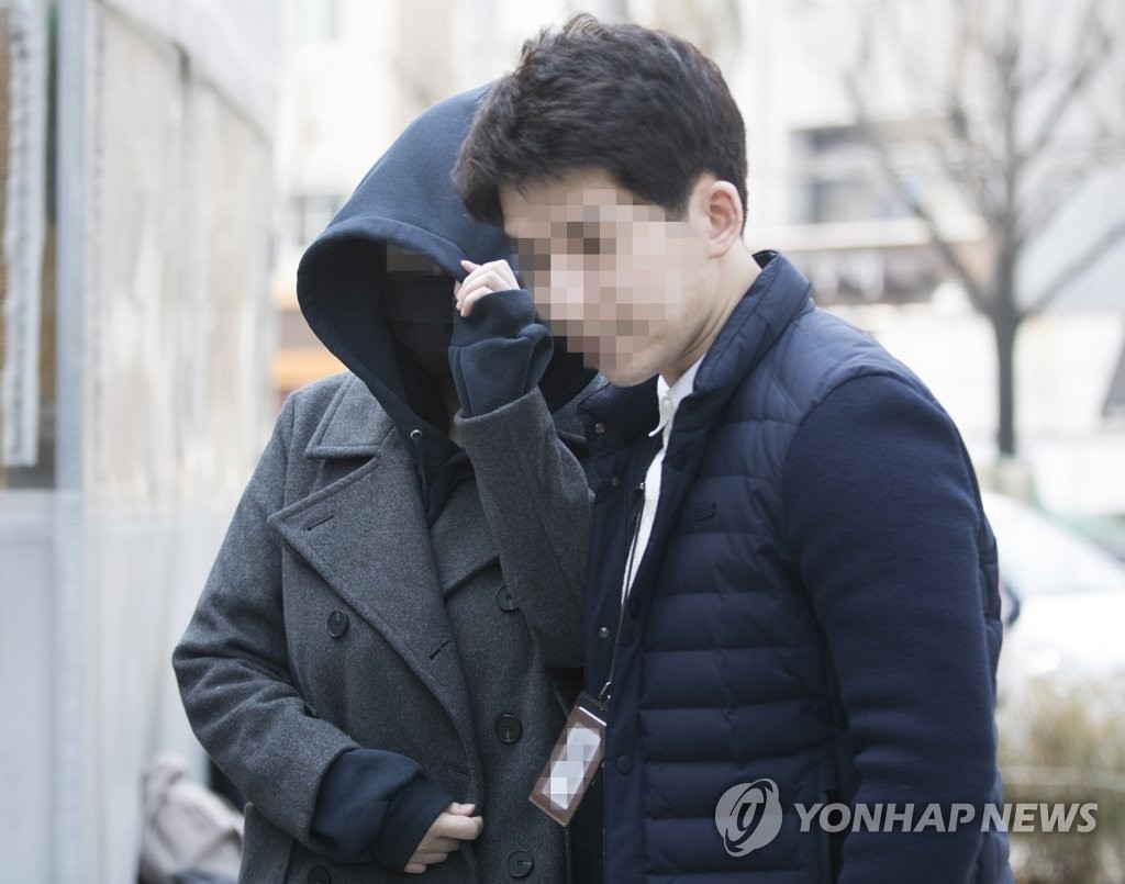 3月19日，在首尔市东大门区，中国籍女子爱娜（左）被带入首尔地方警察厅缉毒科审讯室。（韩联社）