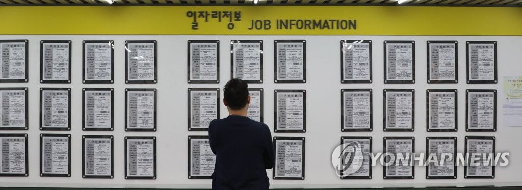 资料图片：一名求职者查看招聘启示。 韩联社