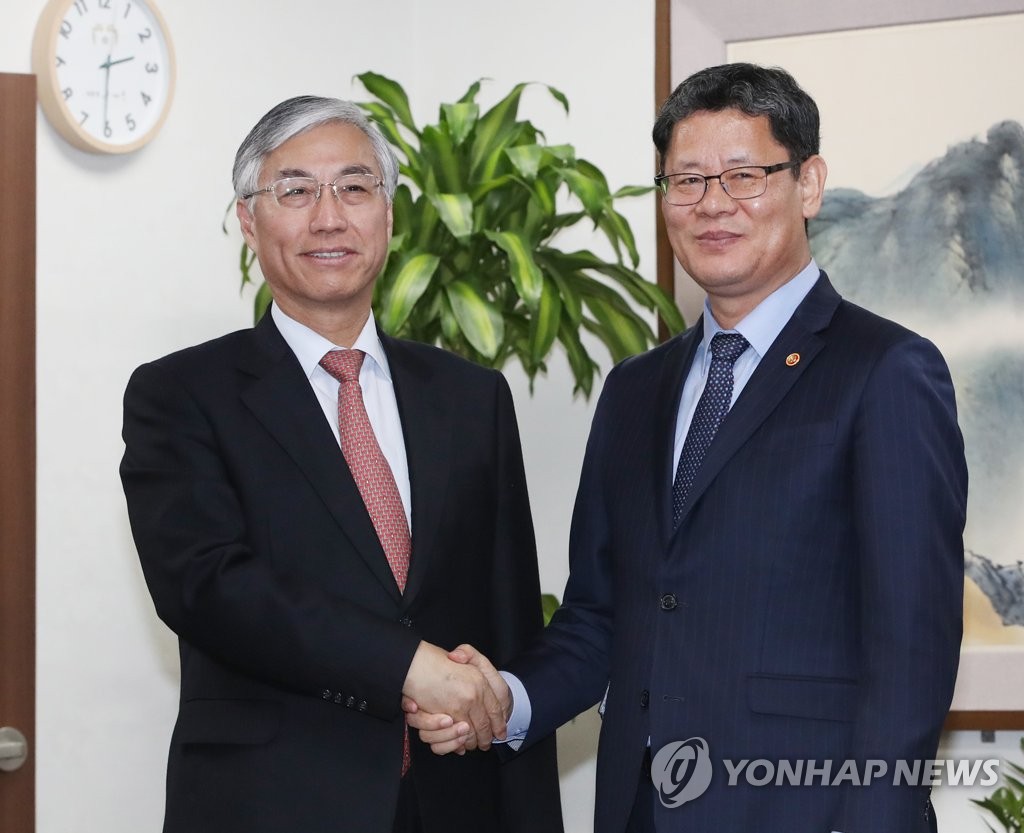 4月17日，在韩国中央政府首尔大楼，统一部长官金炼铁（右）会见中国驻韩大使邱国洪。（韩联社）