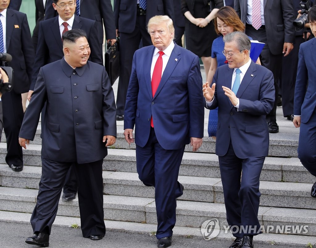 资料图片：2019年6月30日，文在寅（右起）、时任美国总统特朗普、金正恩走出板门店韩方一侧的自由之家。 韩联社