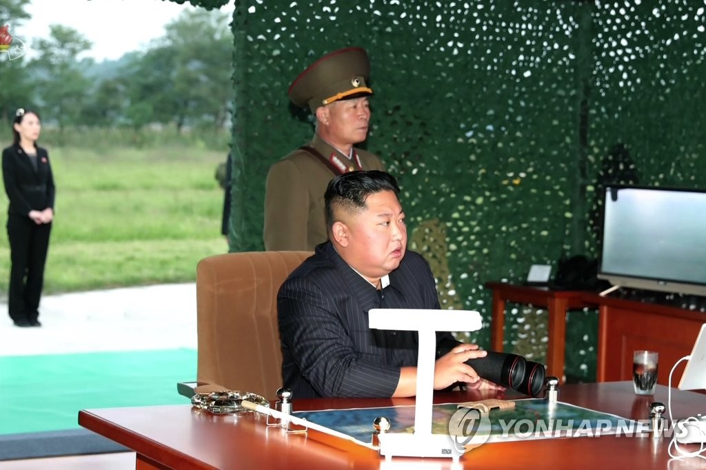 资料图片：2019年9月10日，朝鲜国务委员会委员长金正恩在现场指导超大型火箭炮试射，总参谋长朴正川站在金正恩身旁。 韩联社/朝中社（图片仅限韩国国内使用，严禁转载复制）