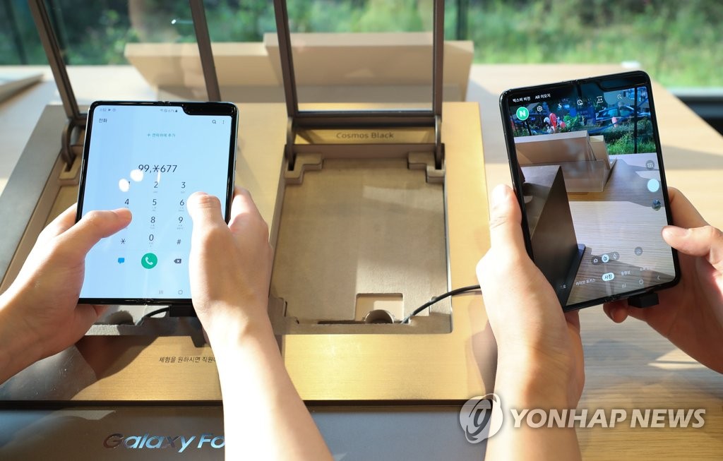 资料图片：10月21日，三星电子首款折叠屏手机Galaxy Fold 5G版正式在韩国发售。图为消费者体验Galaxy Fold 5G版。 韩联社
