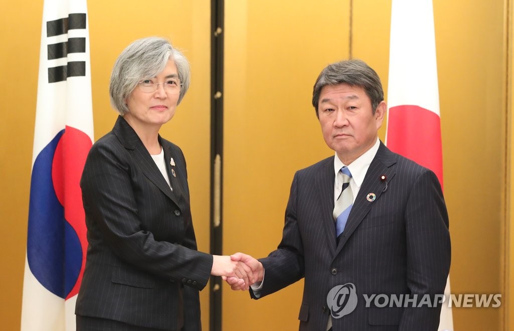 资料图片：11月23日，在日本，康京和（左）同茂木敏充握手合影。 韩联社