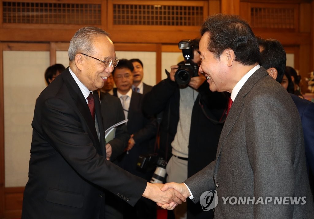 韩国国务总理李洛渊（右）和中国国际经济交流中心理事长曾培炎亲切握手。 韩联社