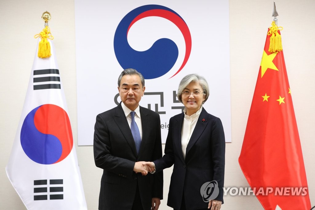 12月4日，在位于首尔的韩国外交部大楼，韩国外交部长官康京和（右）与到访的中国国务委员兼外交部长王毅握手合影。 韩联社
