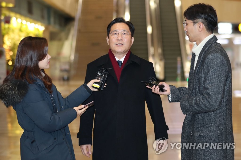 资料图片：12月22日，在金浦机场，韩国产业部长官成允模（中）接受媒体采访。 韩联社
