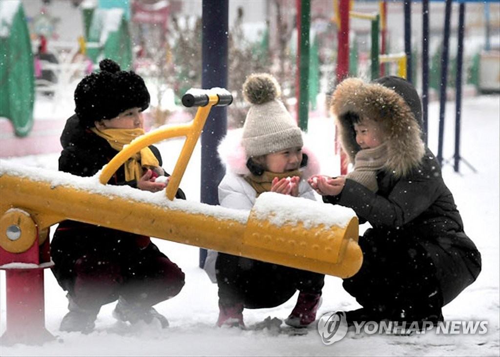 资料图片：玩雪的朝鲜儿童 韩联社/《劳动新闻》朝中社（图片仅限韩国国内使用，严禁转载复制）
