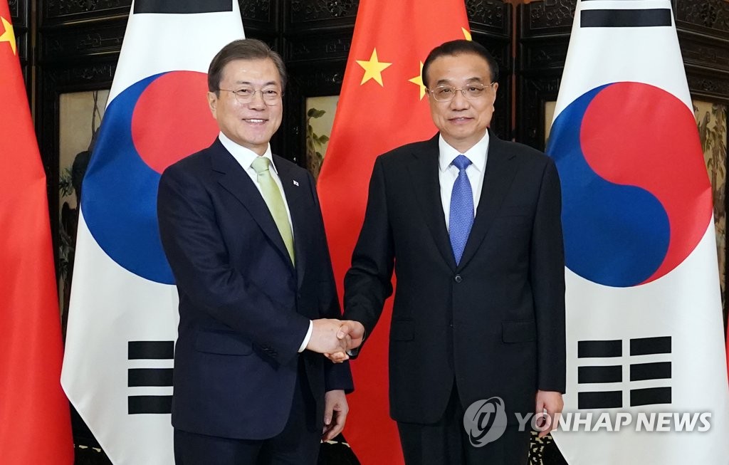 资料图片：韩国总统文在寅（左）与中国国务院总理李克强 韩联社