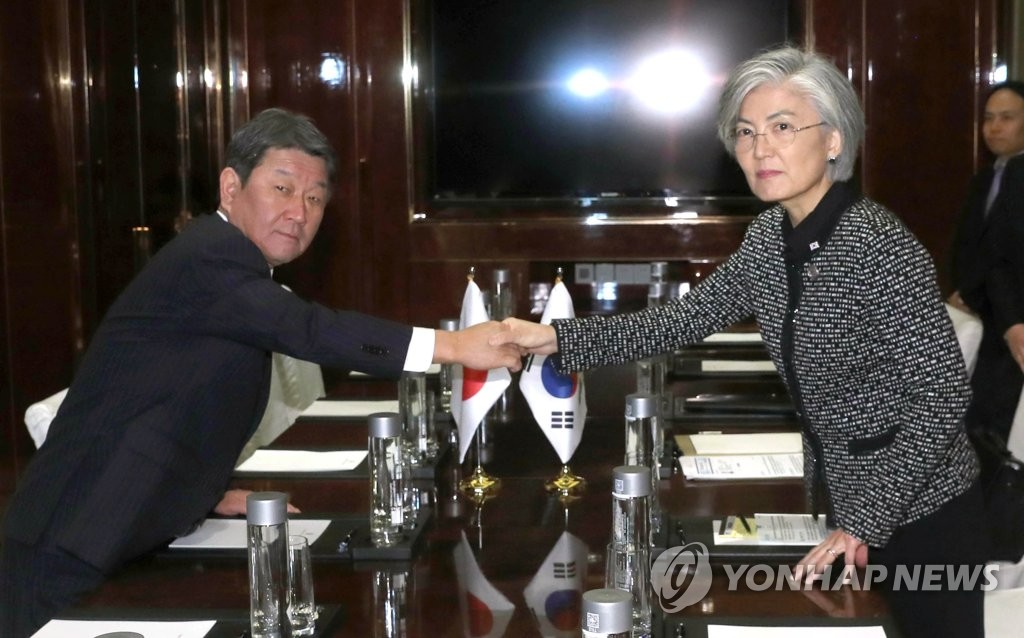 12月24日，在中国成都，韩国外交部长官康京和（右）和日本外相茂木敏充举行会晤前握手合影。 韩联社