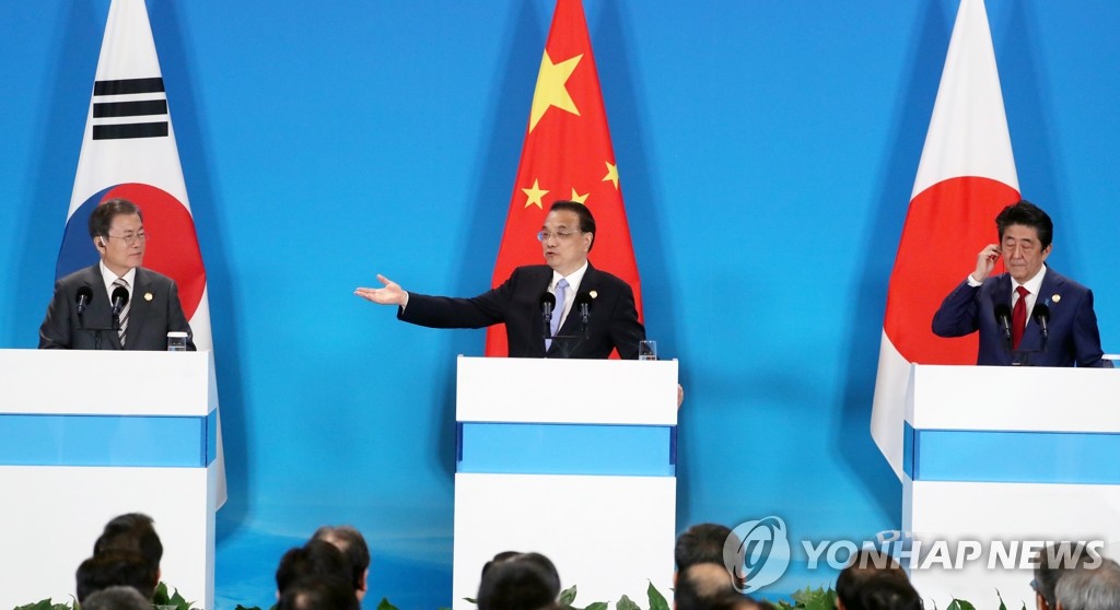 资料图片：12月24日，在成都，韩国总统文在寅（左起）与中国国务院总理李克强、日本首相安倍晋三共同会见记者。 韩联社