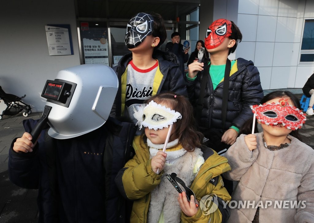 小朋友们带面具观看2019年最后一场日偏食。 韩联社