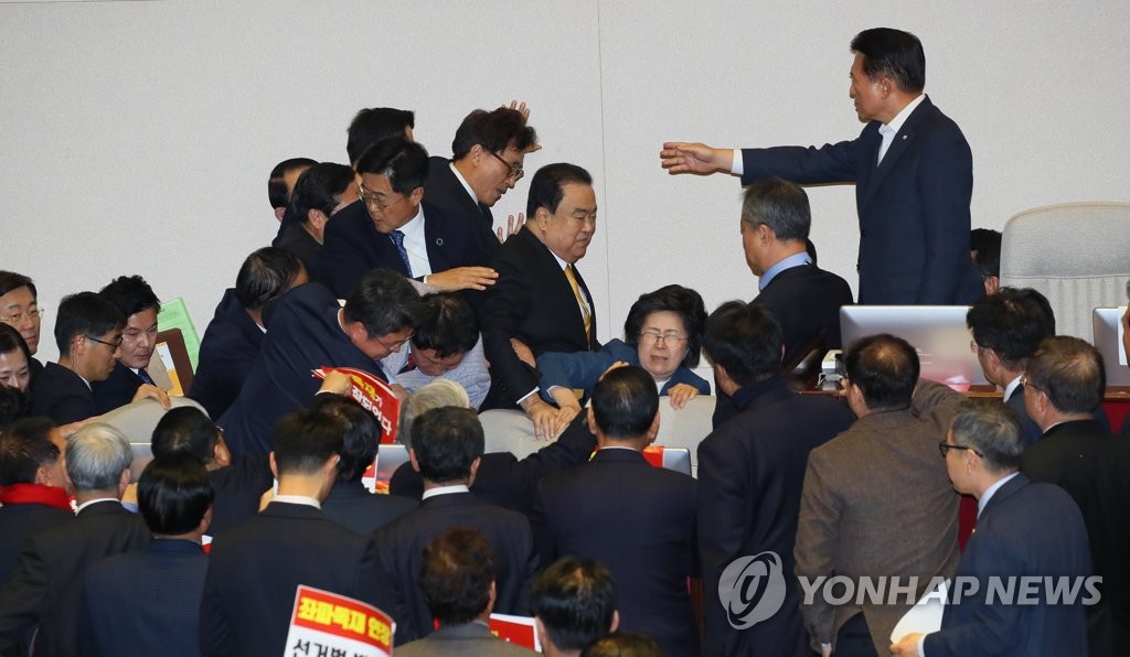 12月27日，在韩国国会，国会议长文喜相（中）在自由韩国党议员的阻挡下走向议长席。 韩联社