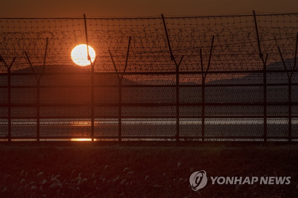 资料图片：透过朝韩边境临津江畔铁丝网看到的夕阳美景 韩联社