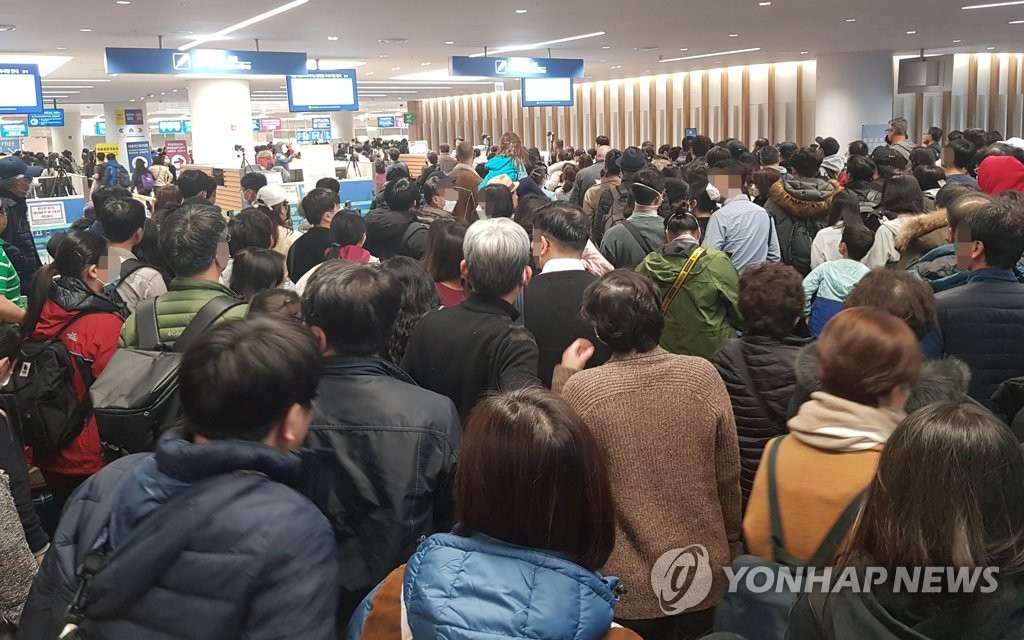 资料图片：1月27日，在仁川国际机场第二航站楼到达厅，大批入境者等候接受检疫。 韩联社