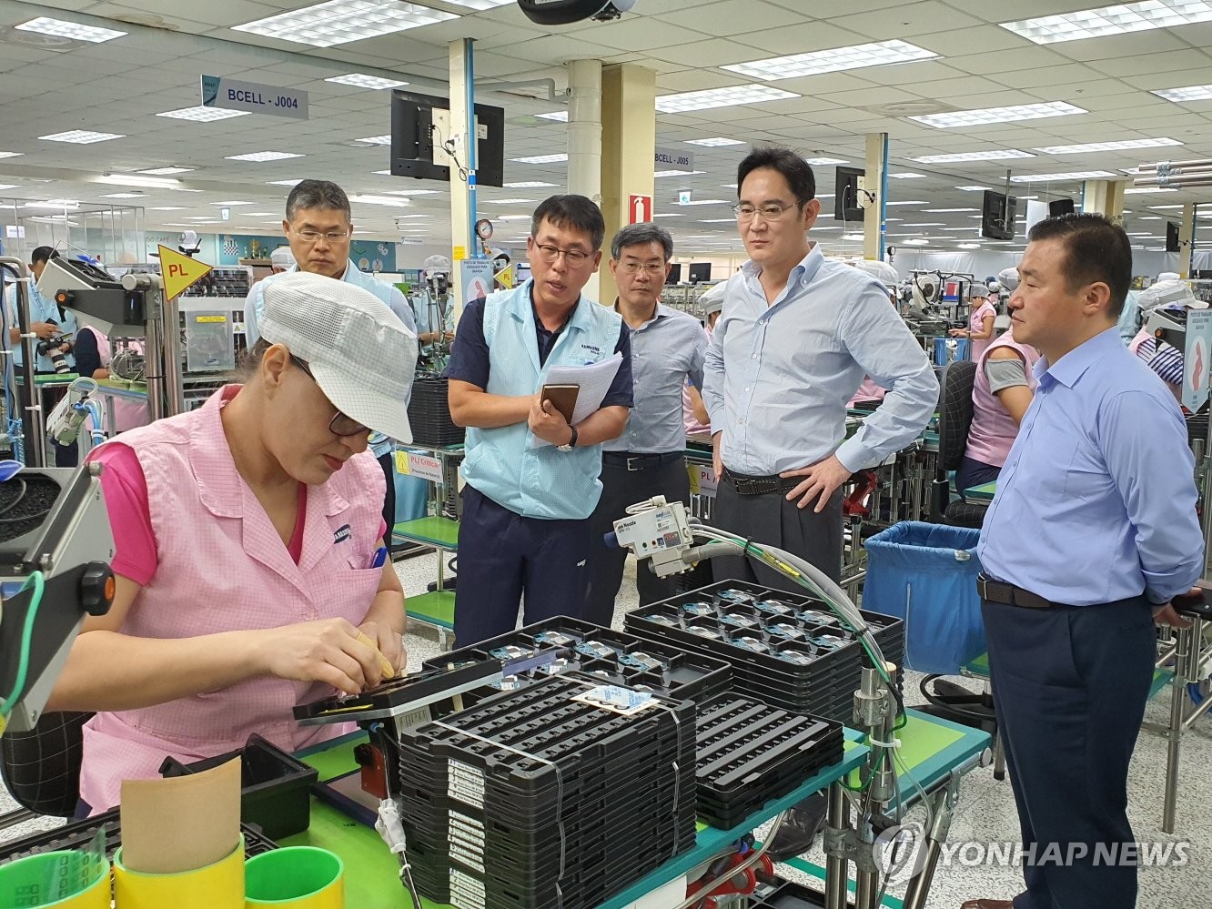 资料图片：1月27日，在巴西玛瑙斯工厂，李在镕（左二）参观智能手机与电视机组装线。 韩联社／三星电子供图（图片严禁转载复制）