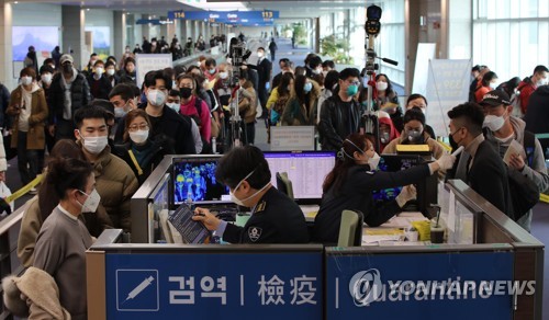 1月29日，在仁川国际机场第一航站楼，来自中国广州的旅客在接受体温检测和健康情况问询。 韩联社