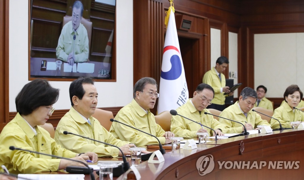 1月30日上午，在首尔，文在寅（左三）主持防疫会议并发言。 韩联社