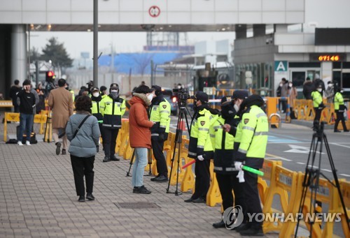 1月31日上午，在金浦机场，韩国警察临时围护转移疫区公民的道路。 韩联社