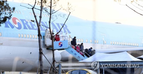 1月31日，韩国首架赴汉撤侨包机返抵首尔金浦机场，乘客👇走下飞机。 韩联社