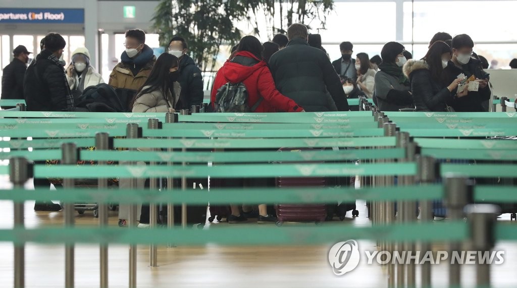 资料图片：1月2日，在仁川国际机场第二航站楼，戴着口罩的旅客等待办理出境手续。 韩联社