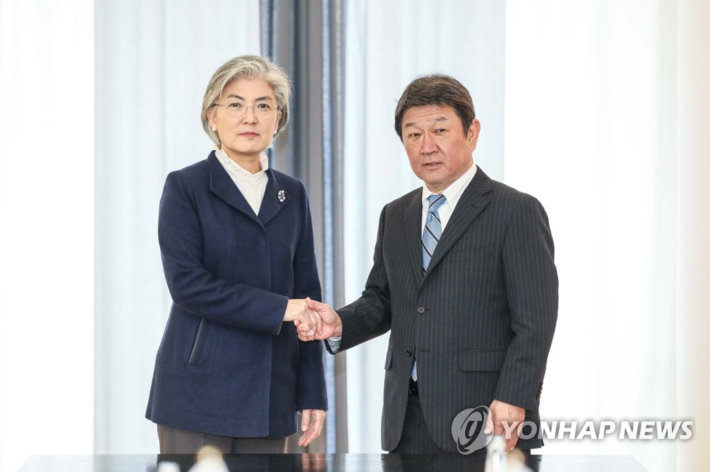 资料图片：当地时间2020年2月15日，在德国慕尼黑，韩国外交部长官康京和（左）与日本外相茂木敏充握手合影。 韩联社/外交部供图（图片严禁转载复制）