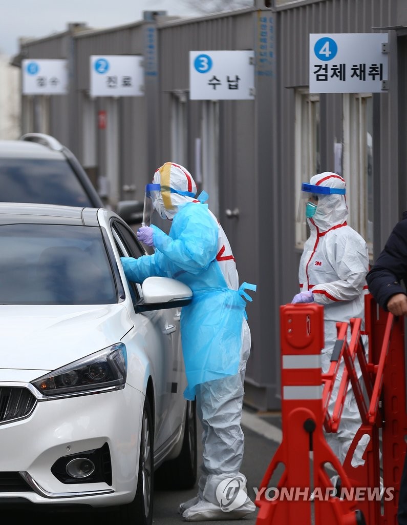 2月27日，在大邱岭南大学医院“免下车”筛查诊所，市民在车内接受新冠病毒检测。 韩联社