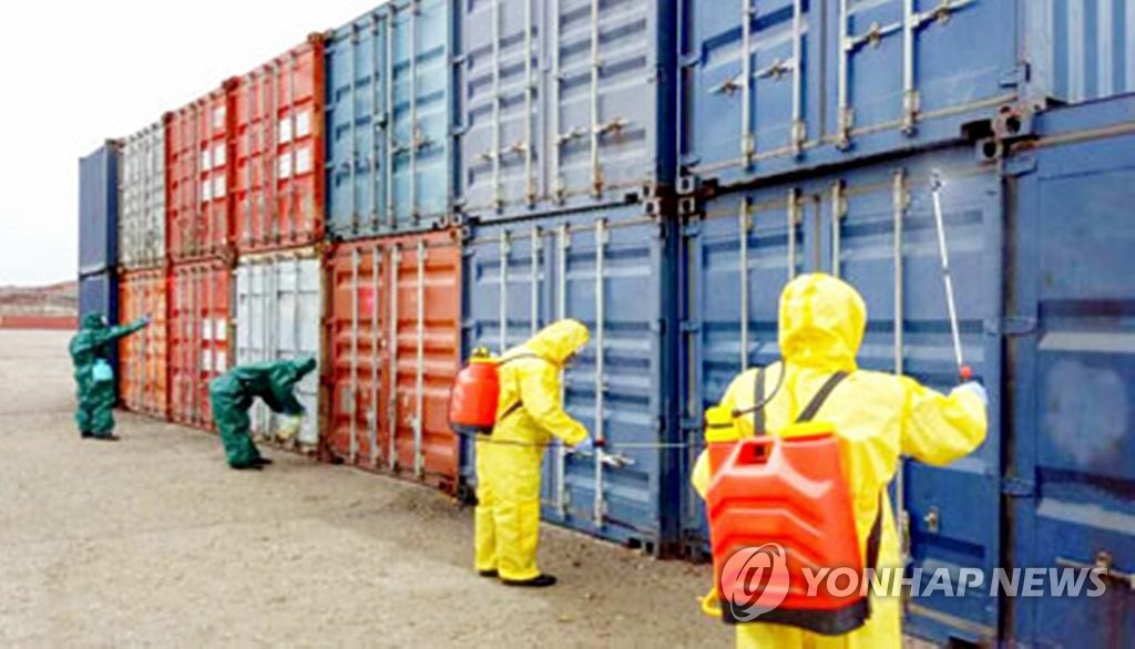 资料图片：3月9日，朝鲜防疫人员在南蒲进出口品检疫所对货物进行消毒，以防止新型冠状病毒传播至境内。 韩联社/《劳动新闻》官网截图（图片仅限韩国国内使用，严禁转载复制）