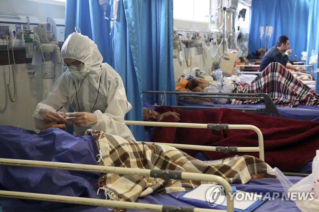 资料图片：当地时间3月8日，在伊朗德黑兰的一家医院，医务人员治疗新冠确诊患者。 韩联社/美联社（图片严禁转载复制）