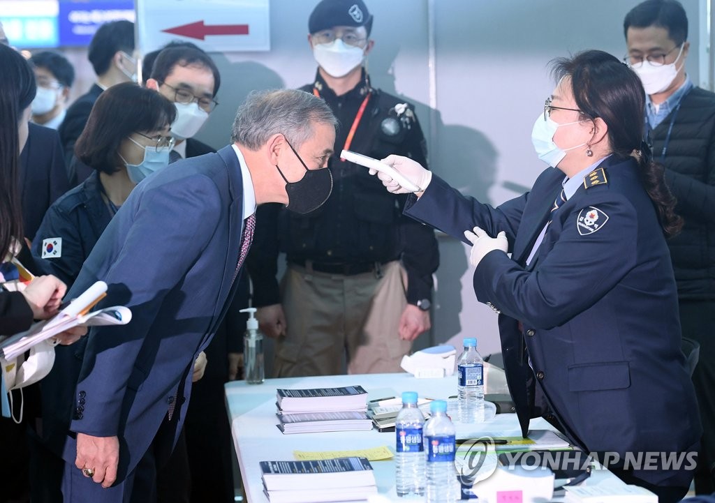 3月11日，在仁川国际机场第二航站楼，美国驻韩大使哈里·哈里斯（左）接受机场测温检疫。 韩联社