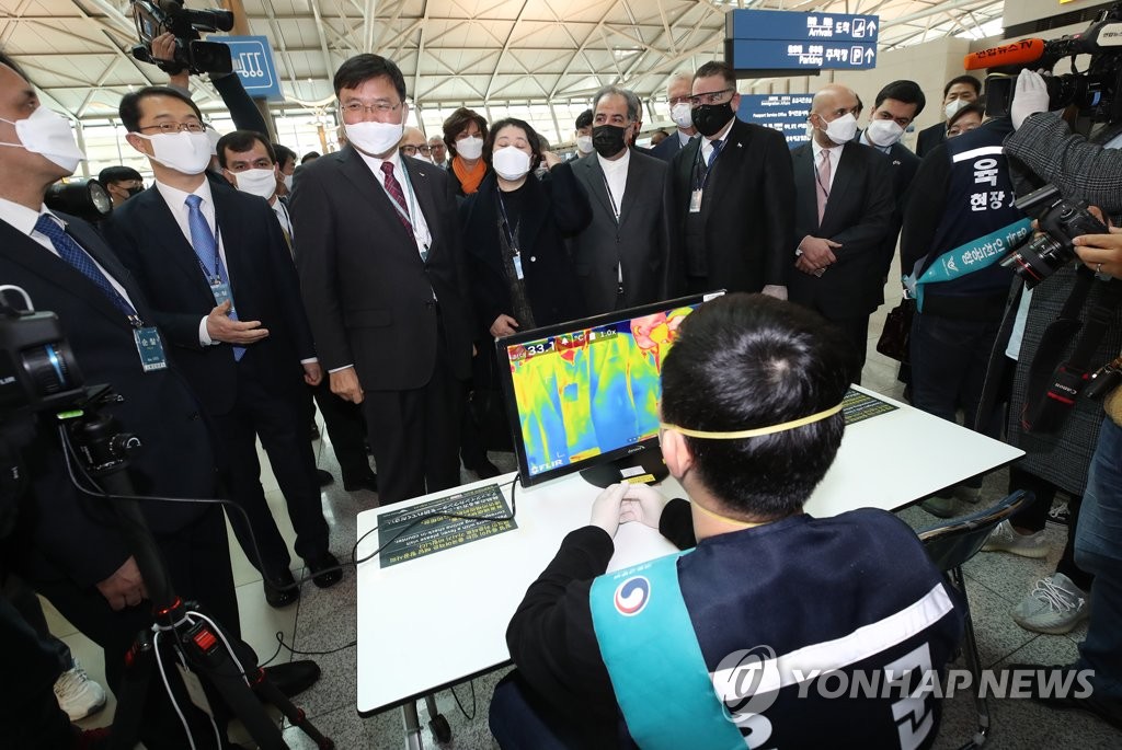 3月13日，在仁川国际机场第一航站楼出入境检疫区，各国驻韩外交使节了解出入境检疫程序。韩联社