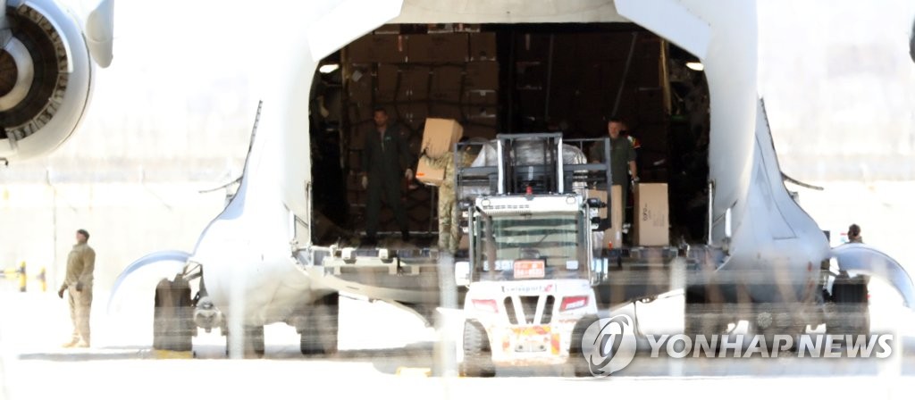 资料图片:3月27日，在仁川国际机场，工作人员将韩国产防护服和新型冠状病毒诊断试剂装运到北约运输机上。 韩联社 