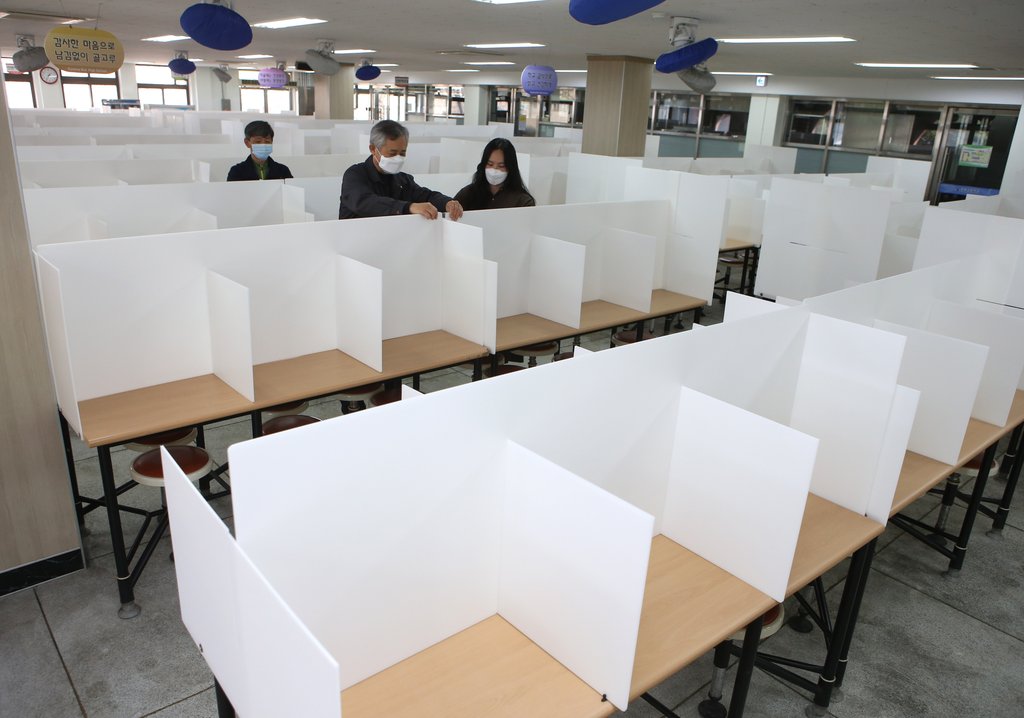 资料图片：3月31日，在大邱市的庆北高中食堂，餐桌上装起隔断板以防新冠病毒感染。 韩联社