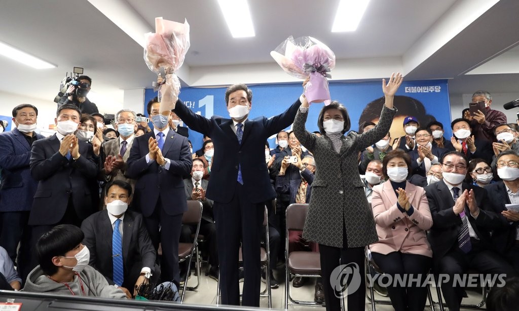 4月15日，首尔市钟路区国会议员选举共同民主党籍候选人李洛渊与夫人在铁定当选后高举花束庆祝胜利。 韩联社