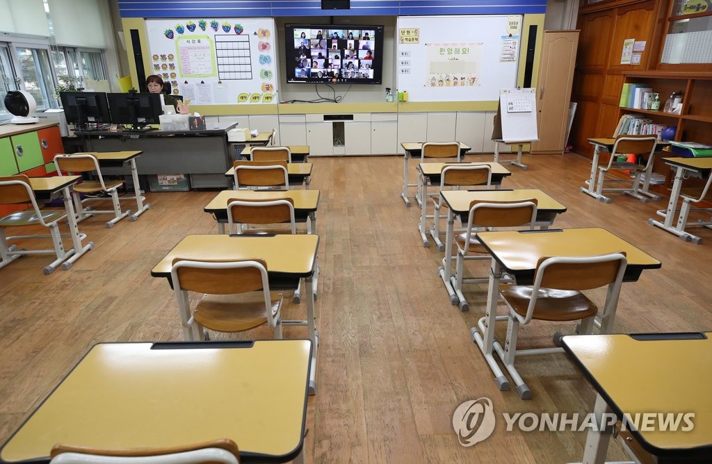 资料图片：4月20日，在首尔龙山区龙山小学一年级教室里，老师与学生们线上交流。受新型冠状病毒（COVID-19）疫情影响，韩国中小学史上首次线上开学，小学一到三年级当天最后一批加入在线上课的行列。 韩联社